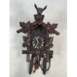 An early 20th century Black Forest cuckoo clock, with oak leaf decoration mounted with a carved deer