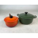A Le Creuset orange sauce pan also with a Le Creuset green cooking pot.
