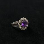 A 14ct white gold amethyst and diamond dress ring . Central amethyst with double twisted surround of
