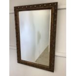 An ornate bevelled edge gilt framed mirror. W:68cm x H:98cm