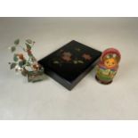 A Japanese lacquer box with a small glass bonsai tree and a Russian doll