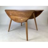 An Ercol blonde mid century elm drop flap dining table.W:63cm x D:113cm x H:72cmExtends to W: