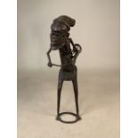 A West African Benin metal figure playing the drum. H:51cm.