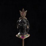 A fine 19th century gold ruby emerald and diamond Blackamoor stick pin. The pin depicting the head