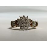 A 9ct gold diamond cluster ring. With diamond set shoulders. 2.7g. Size K.