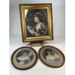 A large coloured print of a Victorian lady in ornate gilt frame with others in oval frames.