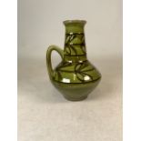 An early 20th century art nouveau waisted ewer with leaf decoration to a green ground. Marked