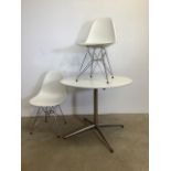 A pair of Vitra Eames plastic chairs with a similar circular table.W:46cm x D:45cm x H:80cm