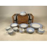 A four place dinner set and tea cups with saucers by Doulton together with a wicker basket