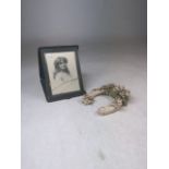 An Edwardian leather travel photo frame and a 1930s wedding favour horse shoe.