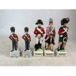 Two Coldstream Guard figures and music box base together with three officer decanters. Tallest: 34cm