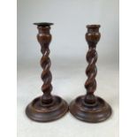 A pair of turned oak candlesticks.H:27cm