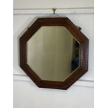 An octagonal oak frame bevelled mirror.W:65cm x H:65cm