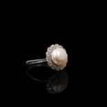 An early 20th century platinum pearl and diamond flower ring . Central set with button natural