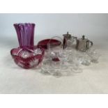 An assortment of glassware to include cranberry glass vase and bowl. A selection of wine and