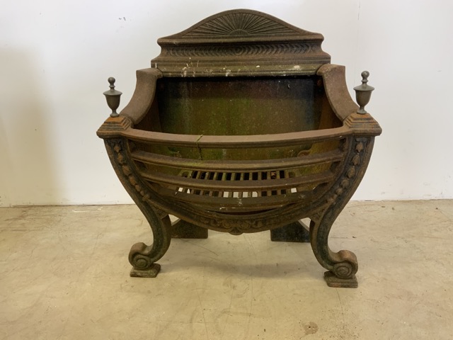 A Victorian cast iron fire basket with later finials.