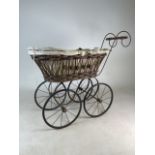 A early 20th century wicker and steel pram with fabric interior and hood