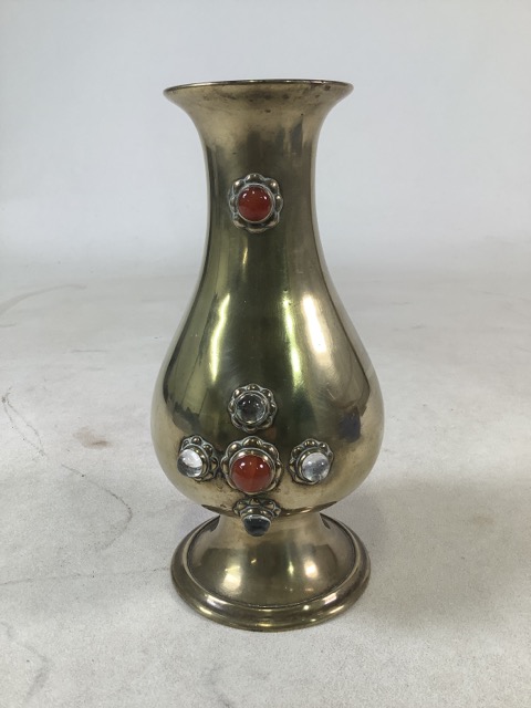 An Arts and Crafts style baluster shaped brass vase with inset glass cabochon decoration. H:26cm