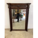 An oak pier mirror with wide bevelled edge with barley twist supports and carved detailing. Some