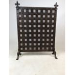 A beaten copper fire screen on legs with decorative fleury de lys finials to top - portcullis style