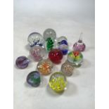 A collection of fourteen paperweights including Caithness. Largest height 10cm.