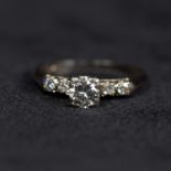 A 14ct white gold and diamond ring. Centrally set with round brilliant cut diamond in a four prong