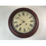 A circular mahogany railway style wall clock with painted metal dial and Roman numeral markers.