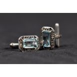 A pair of unmarked white metal and aquamarine set gentlemans cuff links esch set with 14mm x 8mm