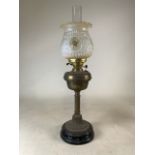 A brass and glass oil lamp with a glass shade and funnel. H:73cm.