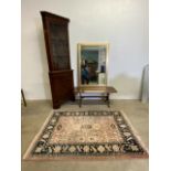 A modern bevelled mirror in gilt frame, reproduction corner cupboard, coffee table and a modern rug.