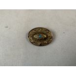 A yellow metal Etruscan style mourning brooch with quartz crystal back and central turquoise