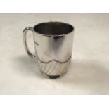 A sterling silver christening mug with half fluted decoration by William Hutton & Sons Ltd,