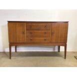 A mid century teak veneered sideboard by Vesper furniture with three central drawers flanked by