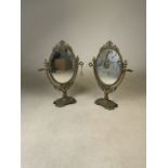 Two brass oval swivel dressing table mirrors. H:39.5cm.
