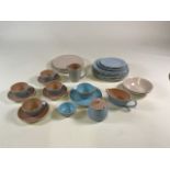 A mixed collection of Poole pottery items including four two tone cups and saucers, a sauce boat