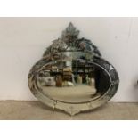 An ornate bevelled oval mirror with etched decoration.W:80cm x H:82cm