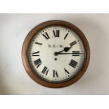 A railway station circular wall clock, the 30cm diameter painted dial with Roman numeral markers and