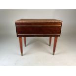 A mid-century sewing stool and bench with leather top and studded detailing. On four legs with brass