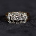 A 15ct gold and diamond three line ring, central graduated line of brilliant cut diamonds flanked by