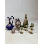 A gilded and hand painted glass decanter with four glasses together with a hand painted and guided