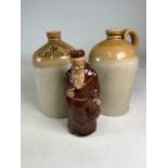 Two pottery alcohol flagons, Bristol and Wareham also with oriental monk decanter. H:26cm