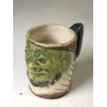 A Blanche Vulliamy, Paul Kruger grotesque mug. Green painted face W:10cm x D:6.5cm x H:9cm (width