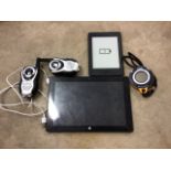 A Kindle tablet together with two portable walkie talkies, a backtrack stop watch and a Intel Lind