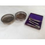 A pair of cased nut crackers also with a pair plated coasters.