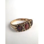 A Victorian 9ct gold and split pearl ring set with three oval free cut red garnets with seed pearl