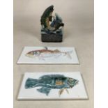 A painted iron fish door stop together with two ceramic fish tiles for display. Door stop Height