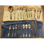 Silver plated knives forks and spoons in cutlery wraps also with silver handled cutlery.