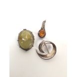 Two silver brooches and a white metal hard stone brooch.