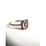 A 9ct gold and amethyst ring, centrally set with emerald cut amethyst in a four claw setting. 1.9g