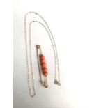 A 9ct gold and coral set pin with a 9ct chain